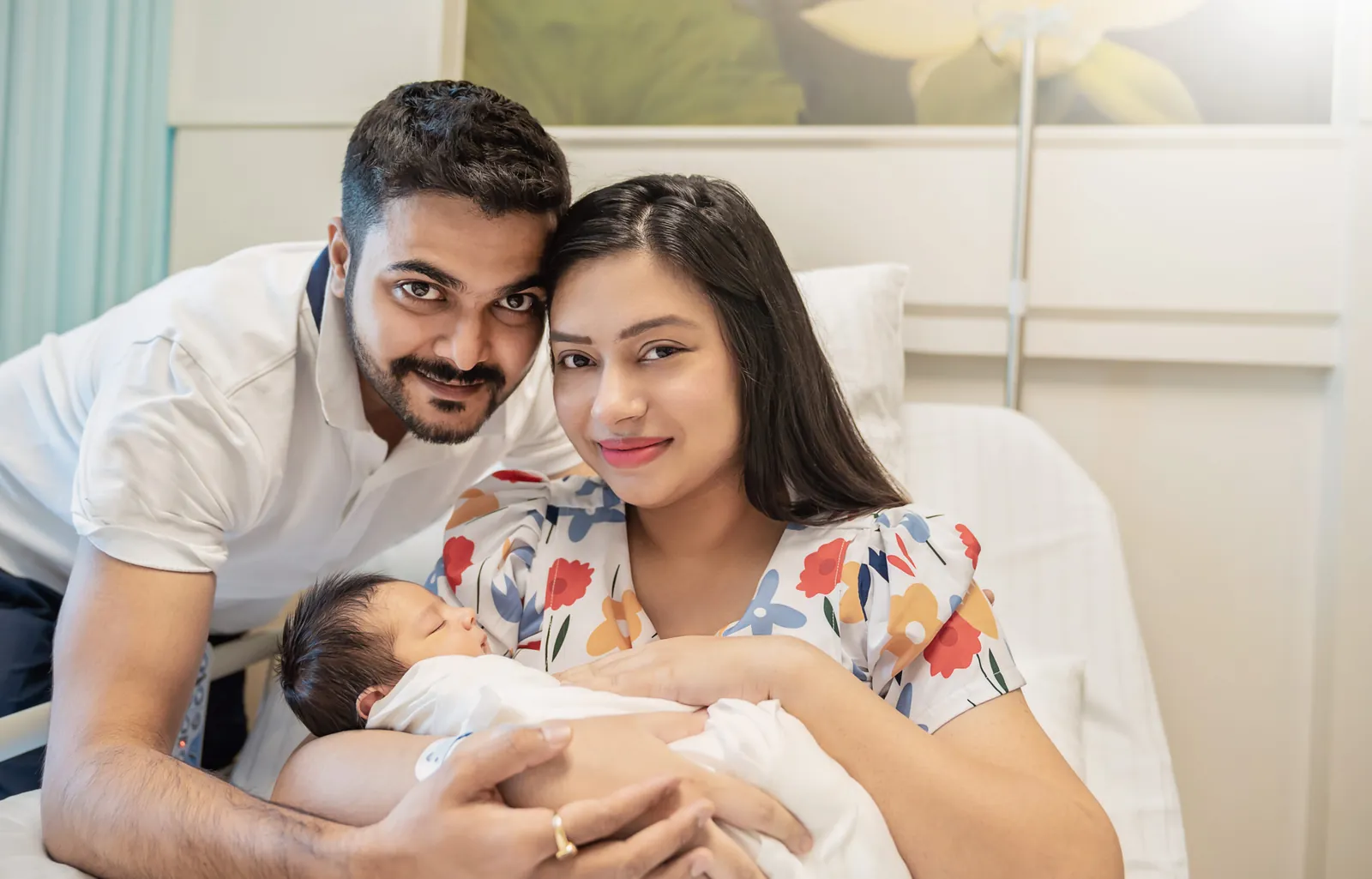 Parents holding their newborn baby in hospital